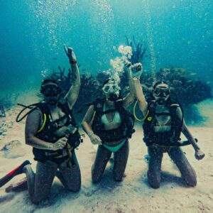 Grupo de buceadores arrodillados en el fondo durante un curso de buceo en la Riviera Maya